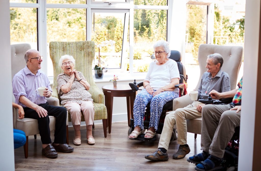 Seniors socializing together while sitting in chairs